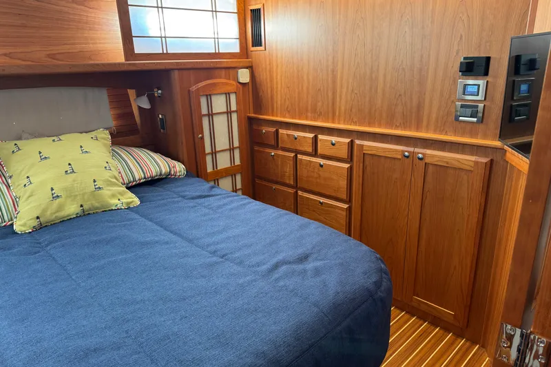 Slide: The Image of 2023 Sabre 48 Salon Express cabin with wooden interior and cozy bedding. - 21