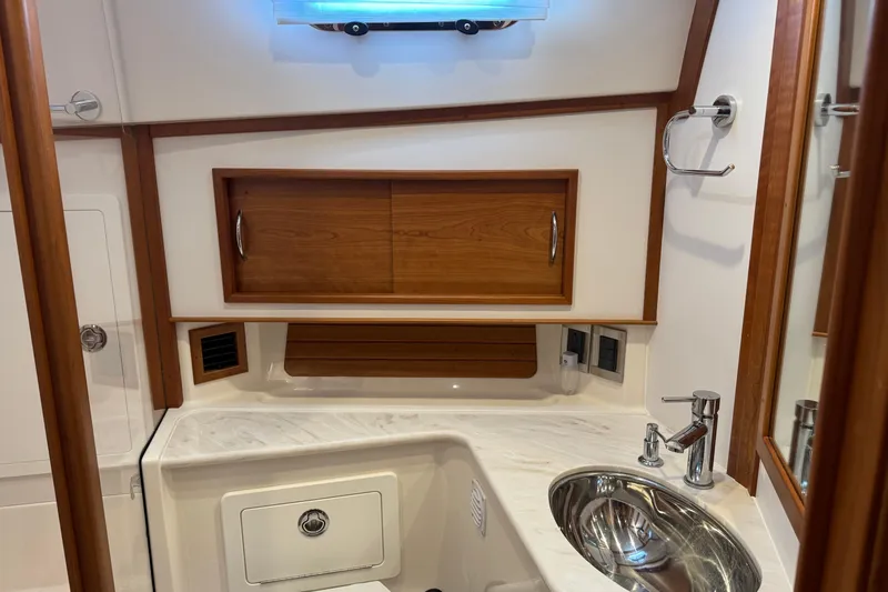 Slide: The Image of 2023 Sabre 48 Salon Express bathroom with wooden cabinets and modern sink design. - 26