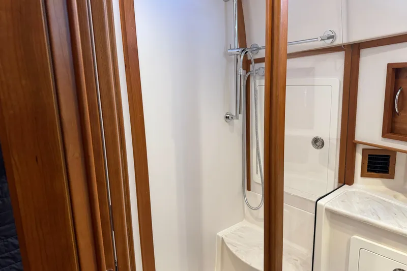 Slide: The Image of 2023 Sabre 48 Salon Express bathroom with wooden accents and modern shower. - 27