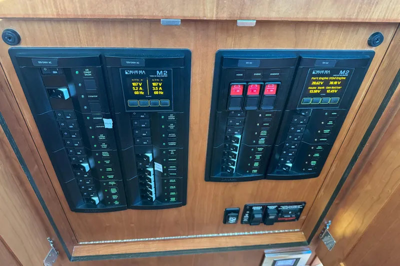 Slide: The Image of Electrical control panel on 2023 Sabre 48 Salon Express yacht, featuring multiple switches and displays. - 29