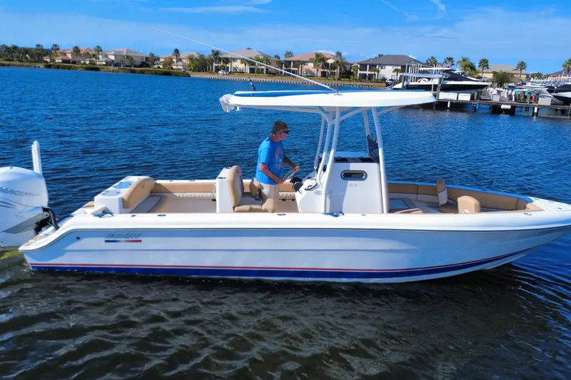 The Image of 2020 Velocity 262cc boat cruising on a sunny day in a scenic waterfront area. - 0