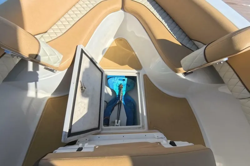Slide: The Image of 2020 Velocity 262cc boat interior with open storage compartment and cushioned seating. - 13