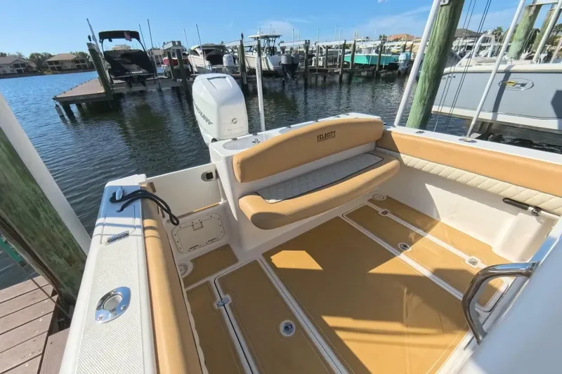 Slide: The Image of 2020 Velocity 262cc boat interior with tan seating, docked at marina. - 16
