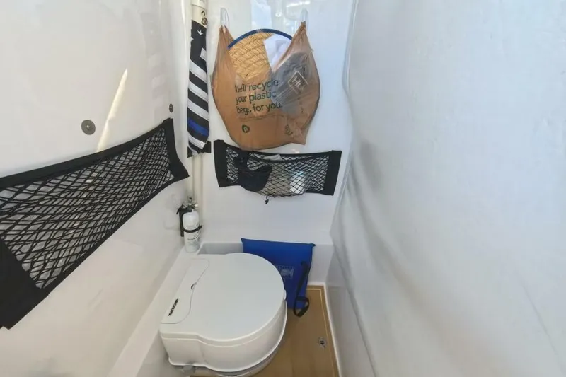 Slide: The Image of Compact bathroom in 2020 Velocity 262cc boat with storage nets and portable toilet. - 19