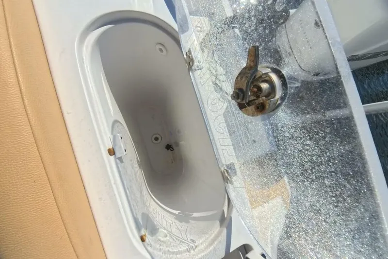 Slide: The Image of 2020 Velocity 262cc boat compartment with latch, featuring white and beige interior. - 21