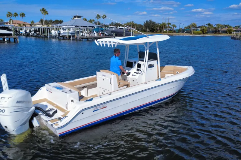 Slide: The Image of 2020 Velocity 262cc boat cruising on a sunny day near a marina. - 30