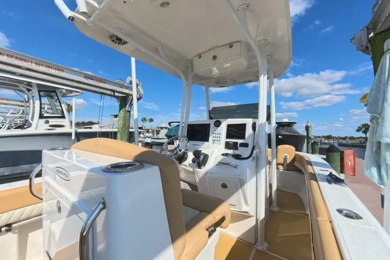 Slide: The Image of 2020 Velocity 262cc boat interior with modern controls and seating at a marina. - 9