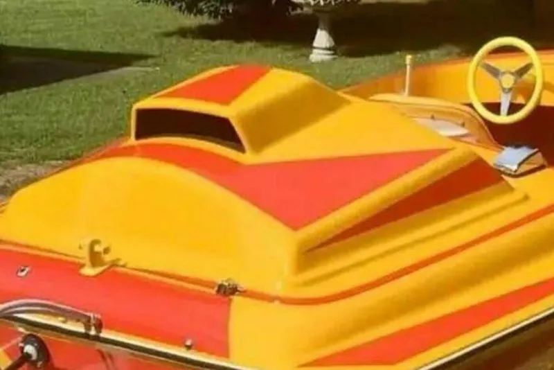 Slide: The Image of 2009 Sleekcraft Kuaui boat with vibrant yellow and red design, featuring a stylish steering wheel. - 14
