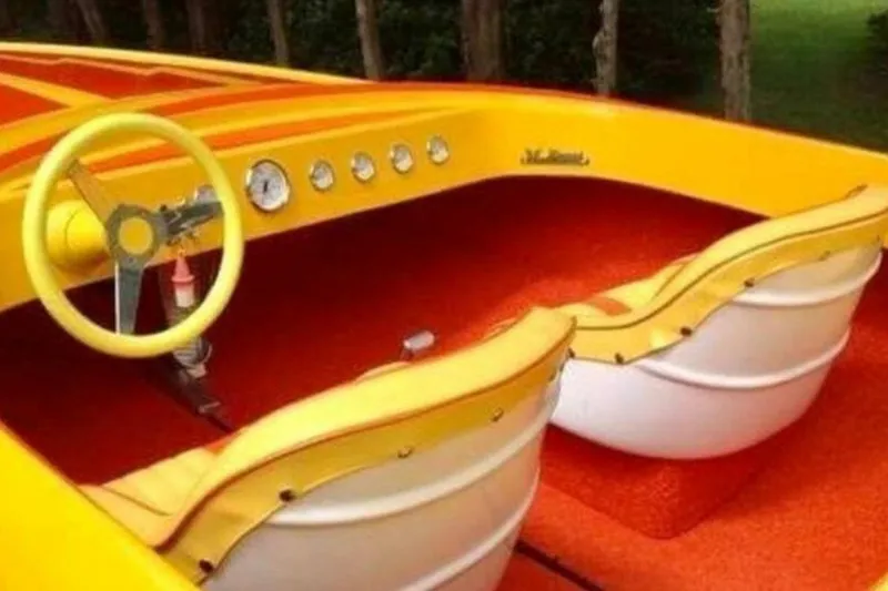 Slide: The Image of 2009 Sleekcraft Kuaui boat interior with yellow and red design, featuring a stylish steering wheel. - 3