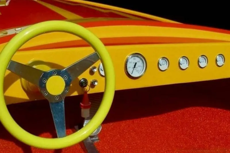 Slide: The Image of Yellow steering wheel and dashboard of 2009 Sleekcraft Kuaui boat with gauges. - 4