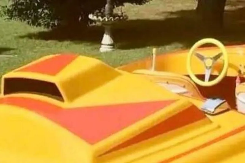 Slide: The Image of Yellow and red 2009 Sleekcraft Kuaui boat with a vibrant design and steering wheel. - 9