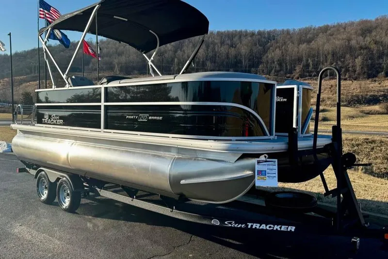 Slide: The Image of 2026 Sun Tracker Party Barge 20 DLX pontoon boat on trailer, scenic background. - 3
