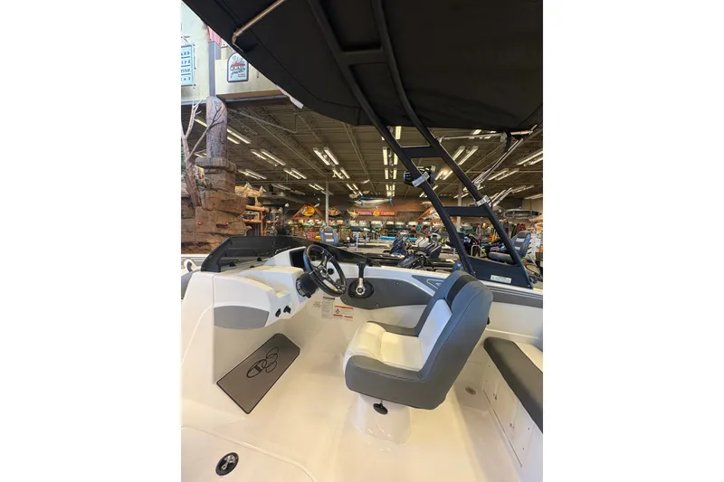 Slide: The Image of Interior view of 2026 Tahoe T21 boat, featuring steering wheel and seating in a showroom. - 103