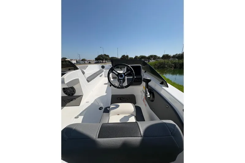 Slide: The Image of 2026 Tahoe T21 boat interior with steering wheel, seats, and dashboard under clear blue sky. - 104