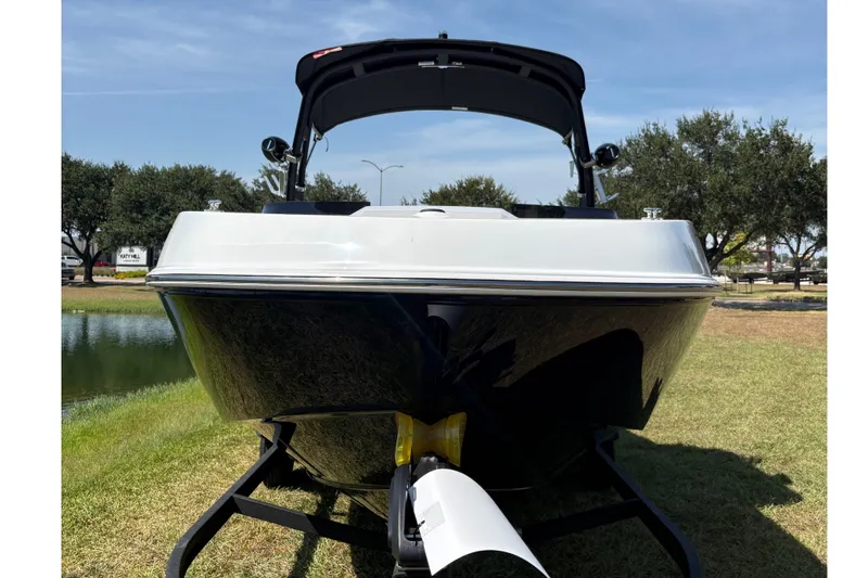 Slide: The Image of The image shows a modern boat on a trailer on grass, with trees in the background. - 3