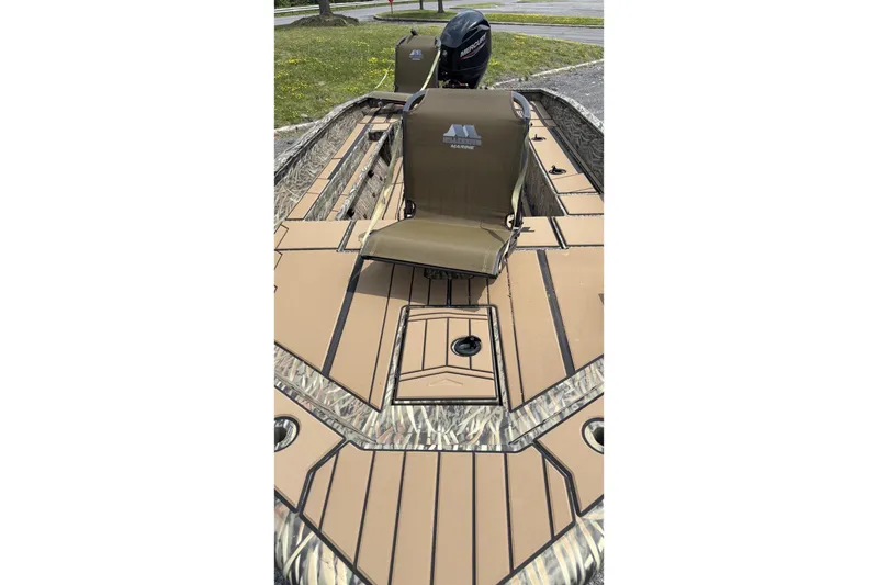 Slide: The Image of 2026 Tracker Grizzly 1756 T Marsh boat interior with seating and Mercury outboard motor. - 2