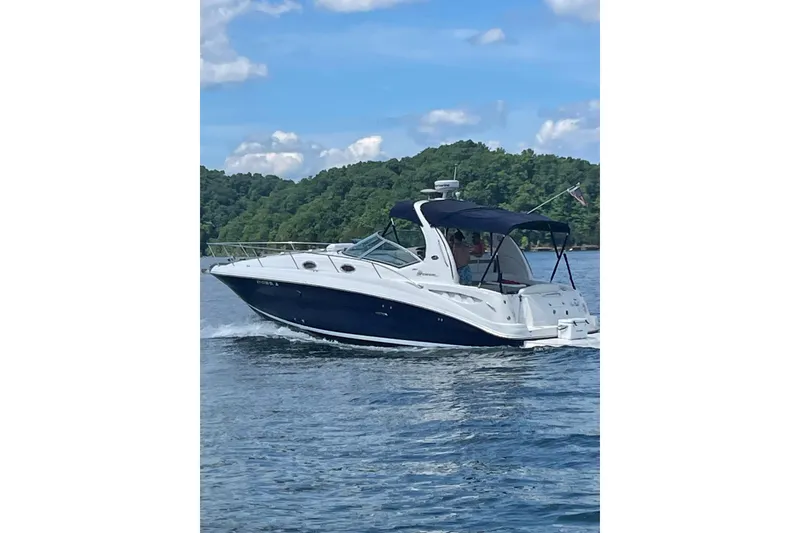 The Image of 2005 Sea Ray Sundancer 320 cruising on a lake with scenic forest backdrop. - 0