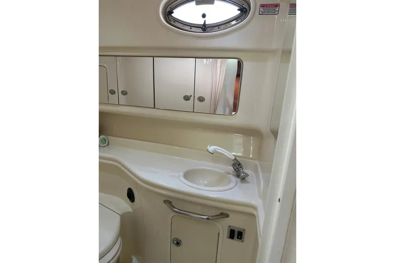 Slide: The Image of 2005 Sea Ray Sundancer 320 bathroom with sink, mirror, and storage cabinets. - 11