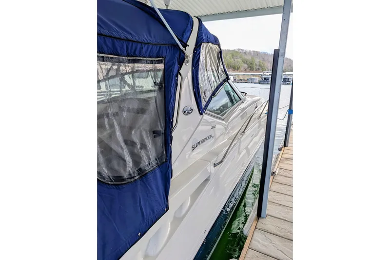 Slide: The Image of 2005 Sea Ray Sundancer 320 docked, featuring blue canopy and sleek design. - 4