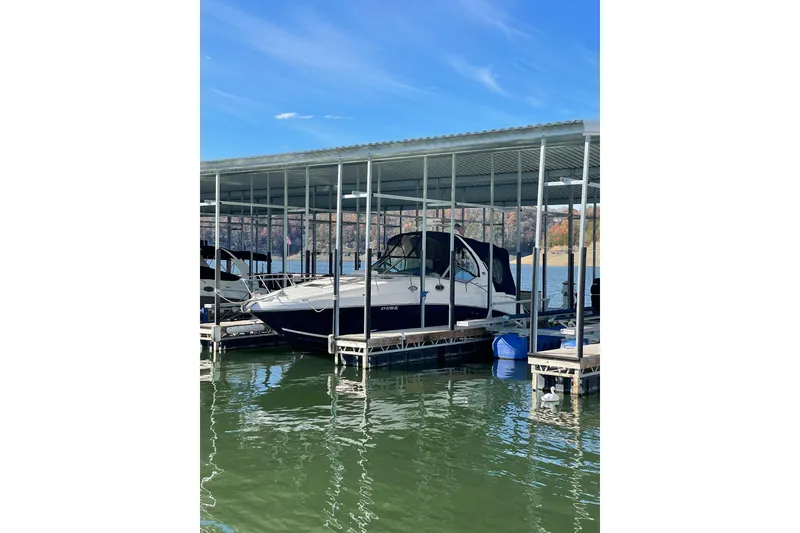Slide: The Image of 2005 Sea Ray Sundancer 320 docked under a covered marina on a sunny day. - 6