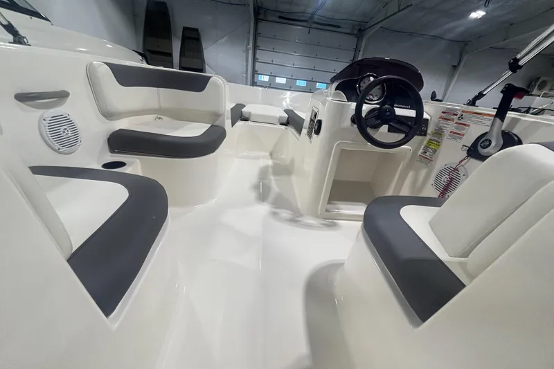 Slide: The Image of 2025 Bayliner Element E16 boat interior with seating and steering wheel in a showroom. - 4