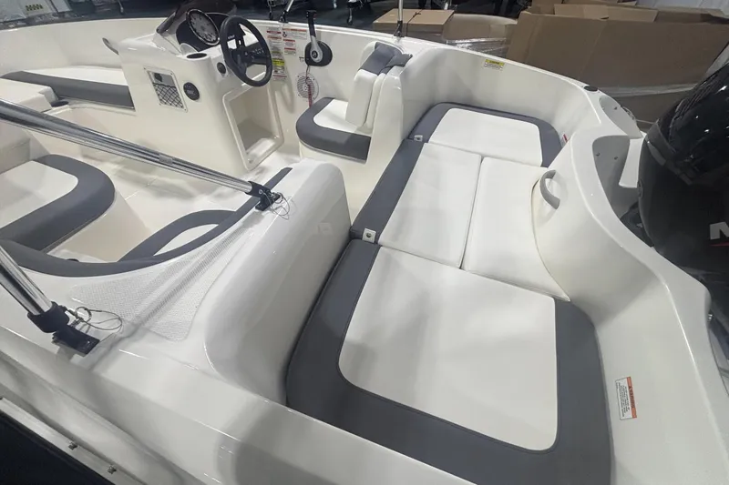 Slide: The Image of 2025 Bayliner Element E16 boat interior with white and gray seating, steering wheel, and controls. - 7
