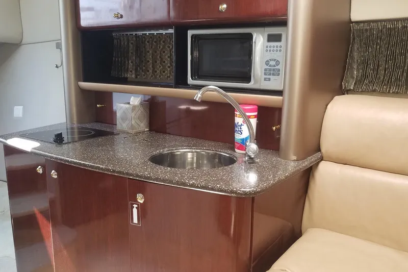 Slide: The Image of 2004 Formula 370 Super Sport yacht interior with kitchenette, featuring sink, microwave, and stove. - 10