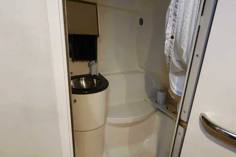 Slide: The Image of Compact bathroom in a 2004 Formula 370 Super Sport boat, featuring a sink and shower. - 13
