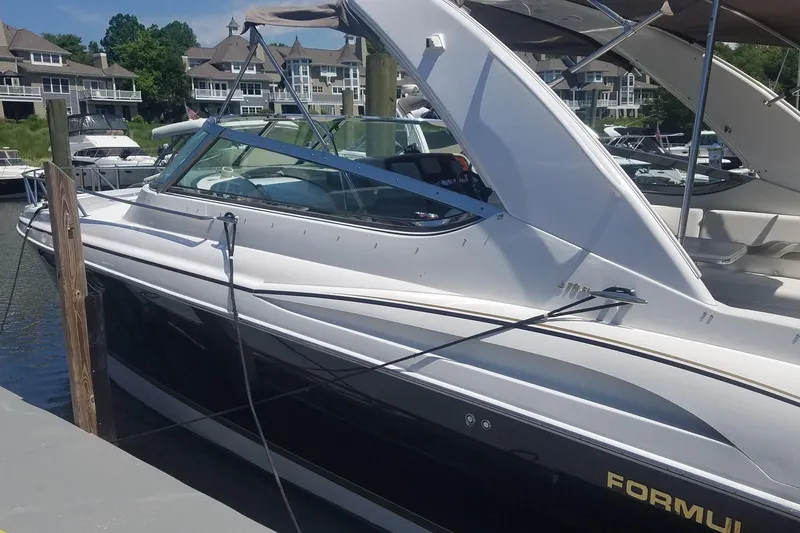 Slide: The Image of 2004 Formula 370 Super Sport boat docked at marina with luxury homes in background. - 4