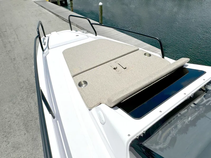 Slide: The Image of 2024 Axopar 25 Cross Top boat with cushioned deck by the water. - 11