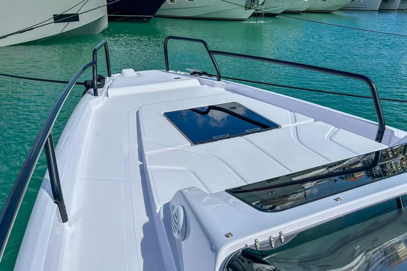 Slide: The Image of 2024 Axopar 25 Cross Top boat deck with sleek design on turquoise water. - 14