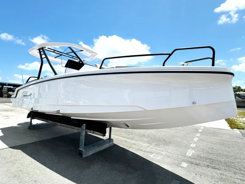 Slide: The Image of 2024 Axopar 25 Cross Top boat displayed outdoors under a clear blue sky. - 3