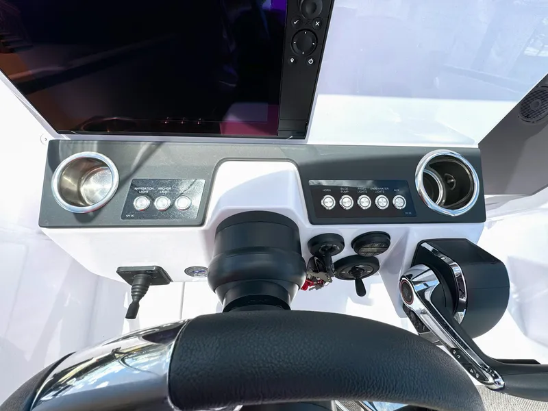 Slide: The Image of 2024 Axopar 25 Cross Top dashboard with steering wheel and control panel. - 9