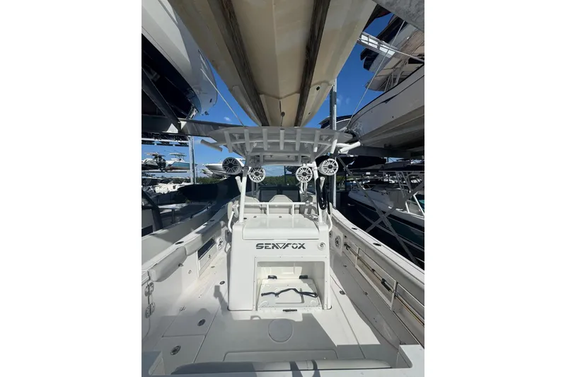 Slide: The Image of 2022 Sea Fox 328 Commander boat interior with seating and speakers, docked in a marina. - 1