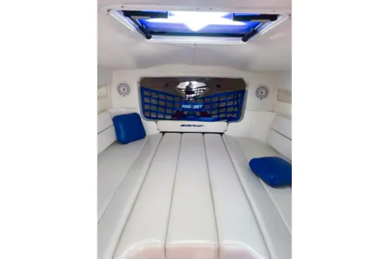 Slide: The Image of Interior cabin of 2001 Sonic 31 SS boat with white seating and blue accents. - 11