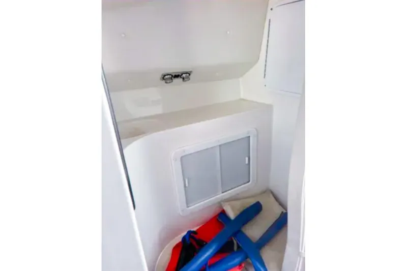 Slide: The Image of Interior storage area of 2001 Sonic 31 SS boat with life jackets and pool noodles. - 12