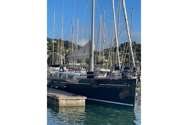 Slide: The Image of 2015 Beneteau Sense 55 sailboat docked, featuring a sleek blue hull and covered deck. - 10