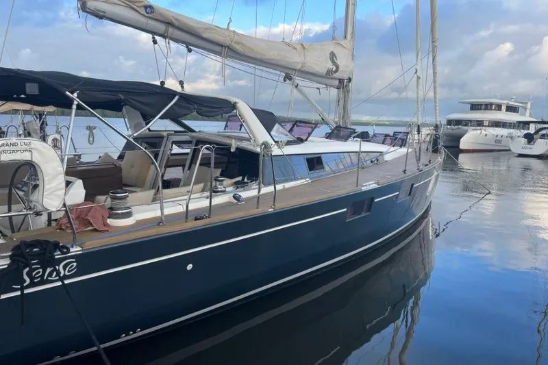 Slide: The Image of 2015 Beneteau Sense 55 yacht docked at a marina with tropical buildings. - 13
