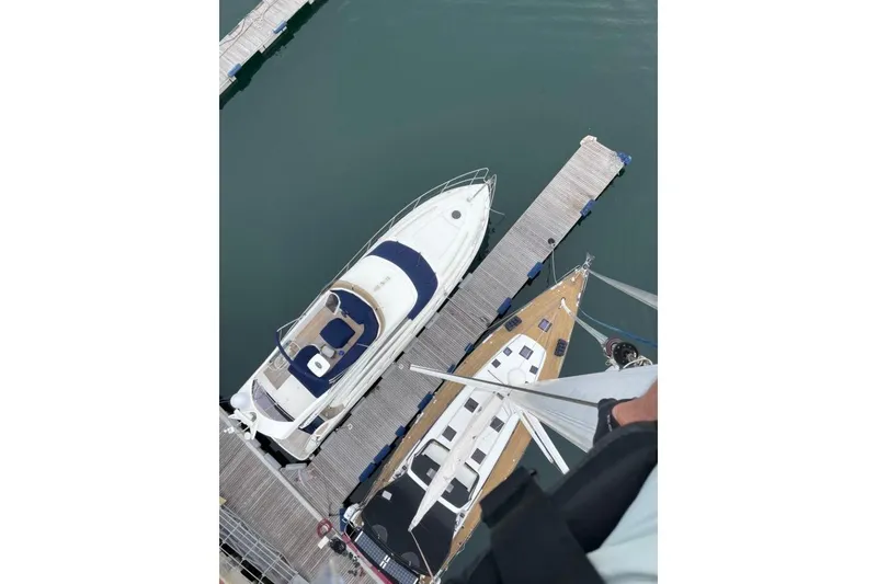 Slide: The Image of 2015 Beneteau Sense 55 sailboat on calm waters, showcasing sleek deck design. - 16