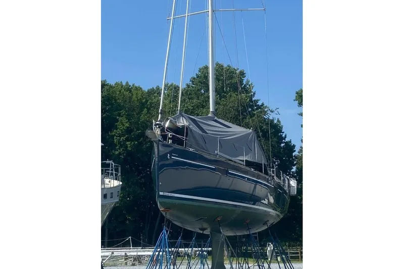 Slide: The Image of 2015 Beneteau Sense 55 yacht on calm water, showcasing sleek deck design and sails. - 17