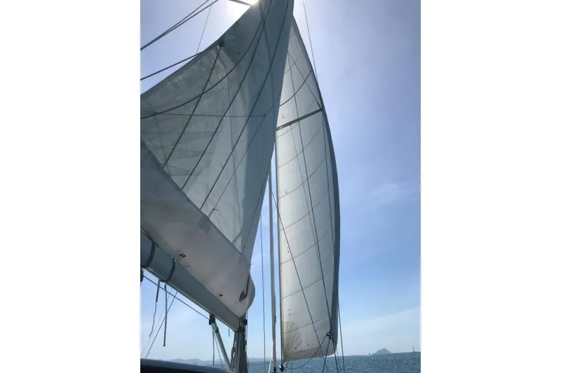 Slide: The Image of Sailing yacht Beneteau Sense 55, 2015 model, with sails unfurled against a clear blue sky. - 3