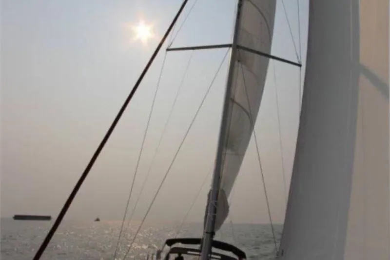 Slide: The Image of Sailboat Beneteau Sense 55 (2015) anchored in a serene coastal bay. - 4