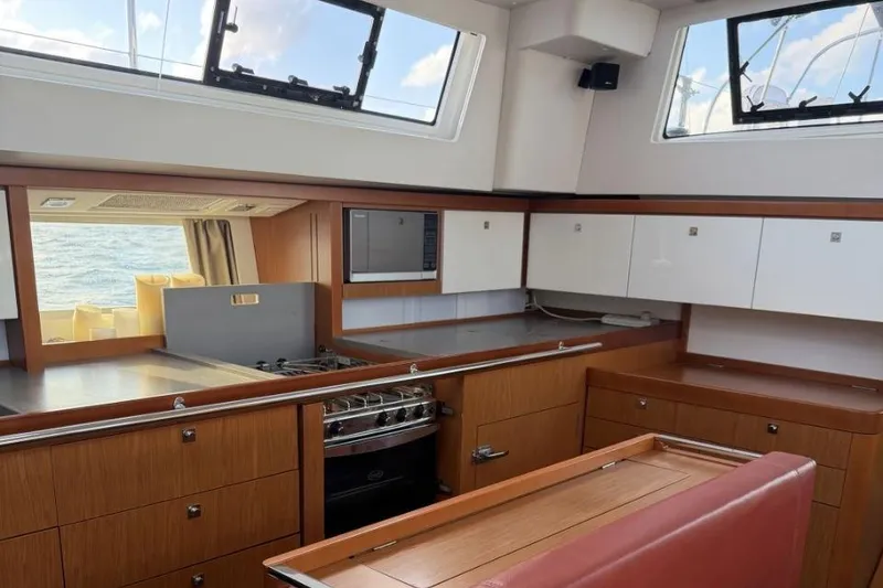 Slide: The Image of Interior of 2015 Beneteau Sense 55 yacht kitchen with modern appliances and wood cabinetry. - 51