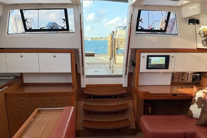 Slide: The Image of Interior of 2015 Beneteau Sense 55 yacht, featuring navigation station and wooden cabinetry. - 53