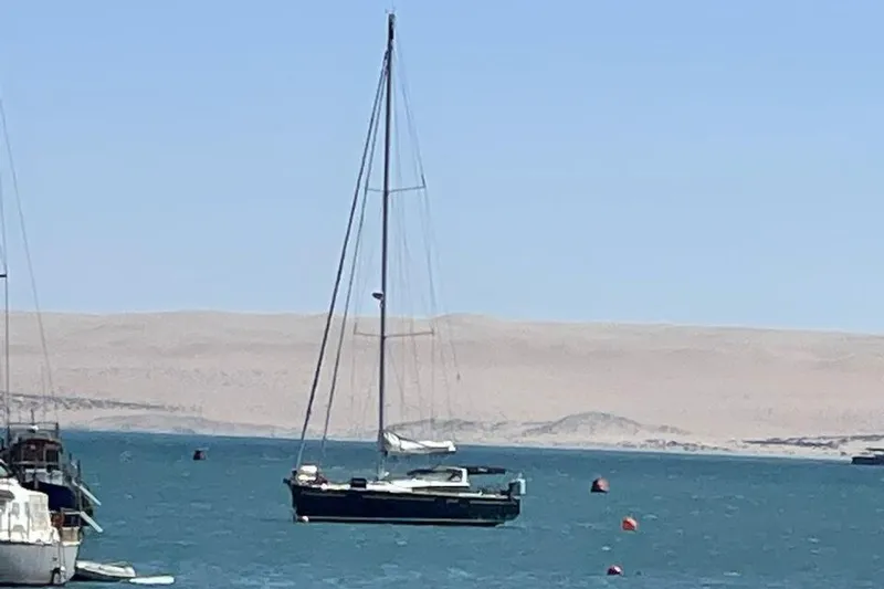 Slide: The Image of Sailing yacht Beneteau Sense 55, 2015 model, anchored near rocky cliffs. - 6