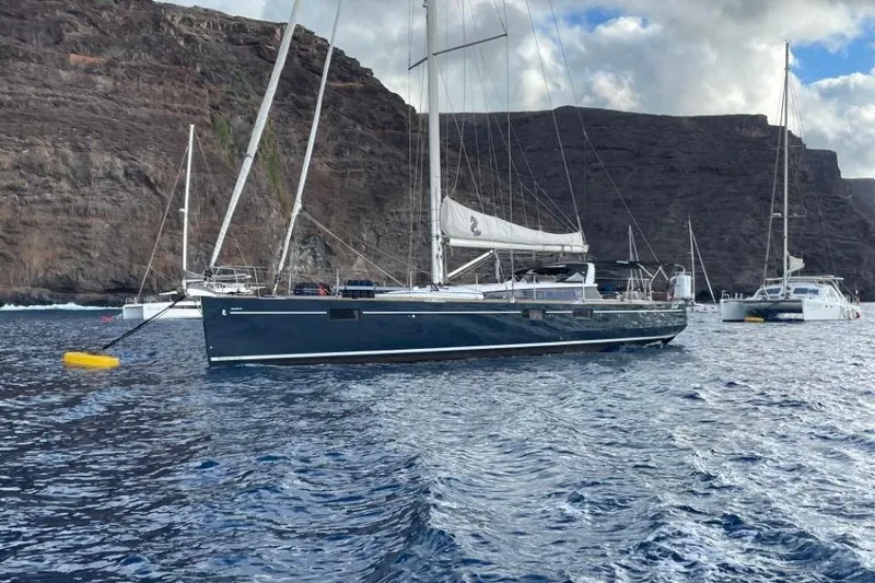Slide: The Image of 2015 Beneteau Sense 55 sailboat docked in turquoise water, front view. - 7
