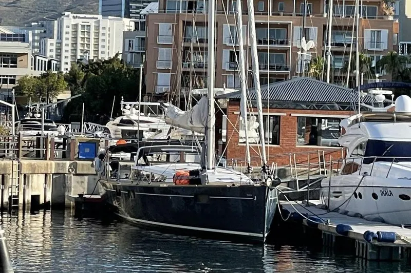 Slide: The Image of 2015 Beneteau Sense 55 sailboat docked in a marina, surrounded by other yachts. - 9