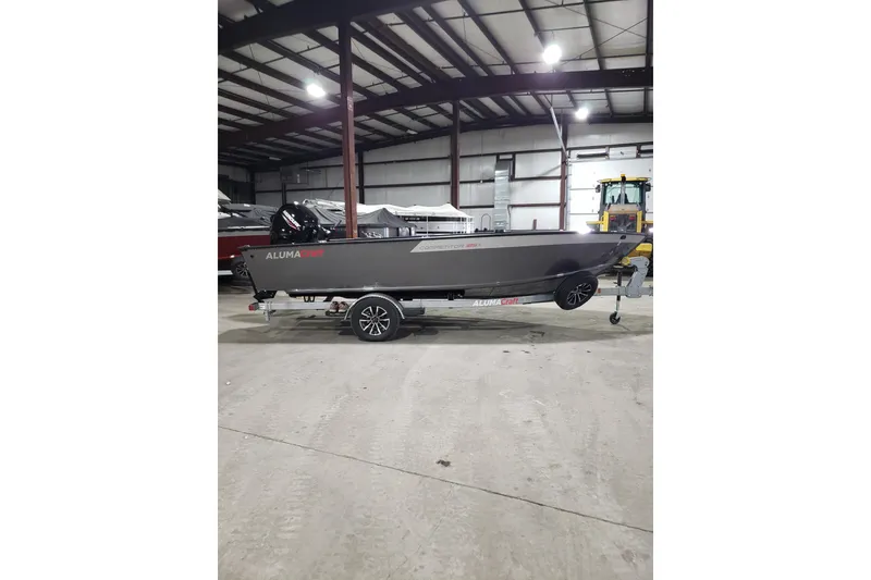Slide: The Image of 2026 Alumacraft Competitor 185X Tiller boat in a warehouse setting. - 19