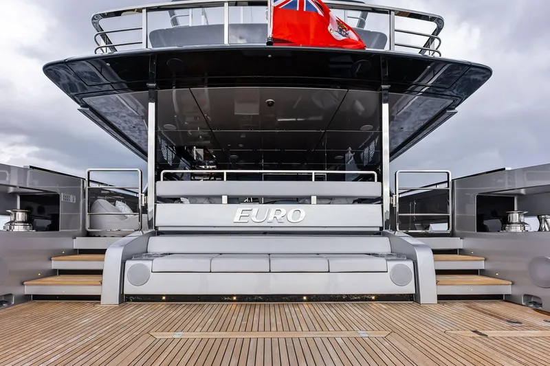 Slide: The Image of 2024 Riva 130' Bellissima yacht stern view with wooden deck and flag. - 20