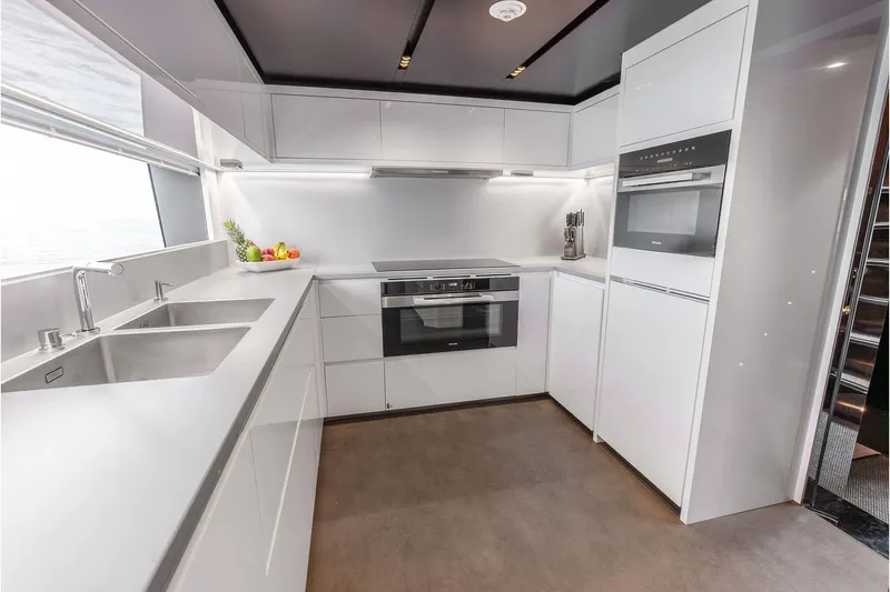 Slide: The Image of Modern kitchen interior on 2024 Riva 130' Bellissima yacht, featuring sleek white cabinetry and appliances. - 32